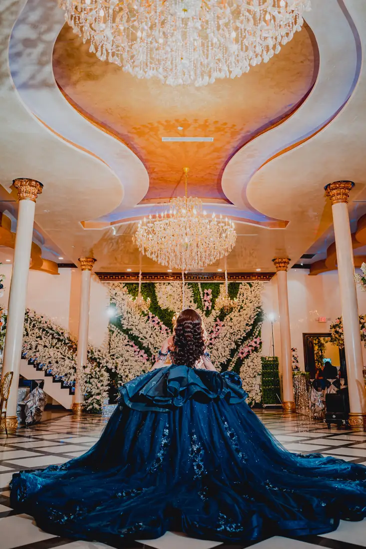 Quinceañera surrounded by floral wings at Arelis Celebration Hall