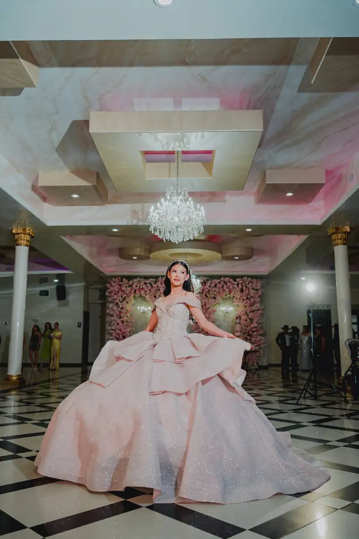 Quinceañera in blush gown under the grand ballroom ceiling at The Grand Villa, Mission TX
