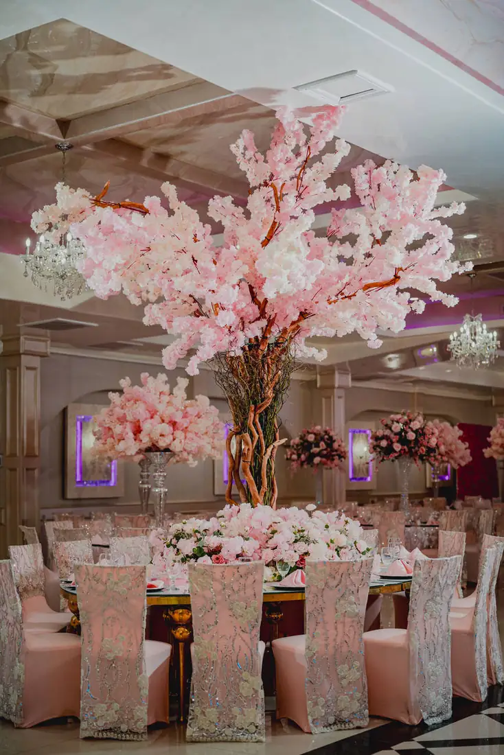 Cherry blossom tree centerpiece over guest tables at The Grand Villa event hall