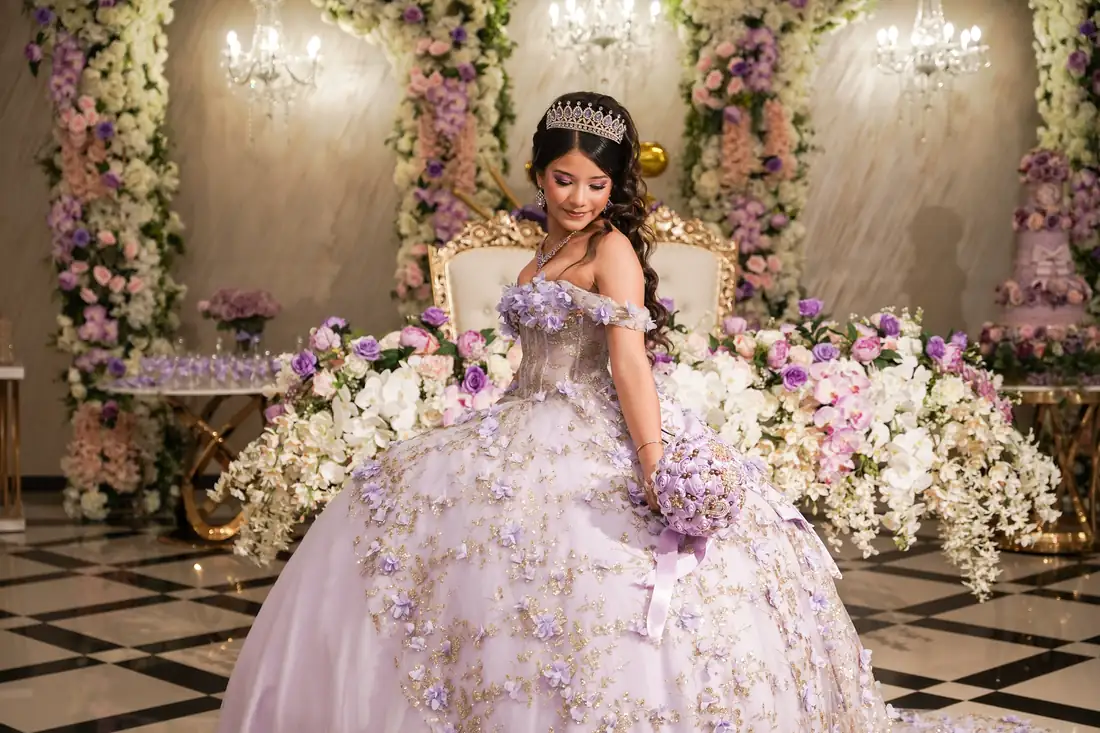 Quinceañera on her floral throne at The Grand Villa reception hall